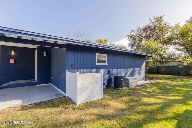 view of property exterior with a yard and central AC unit