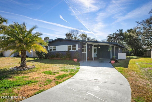 ranch-style house featuring a front yard and a carport