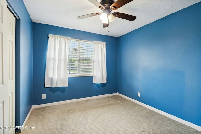 carpeted empty room featuring a textured ceiling and ceiling fan