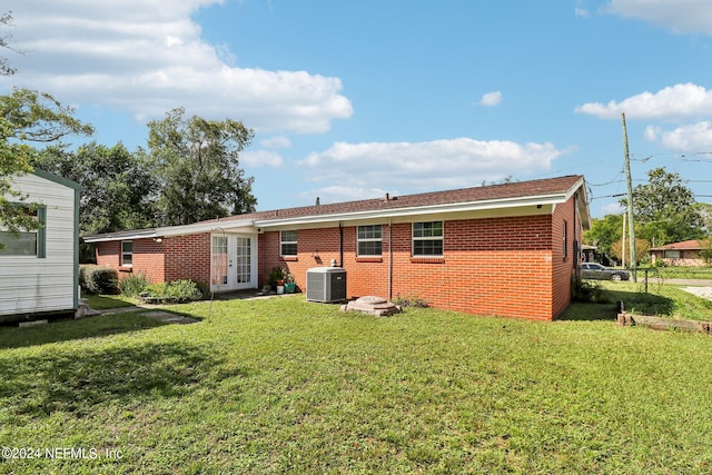 back of house featuring french doors, central AC, and a lawn