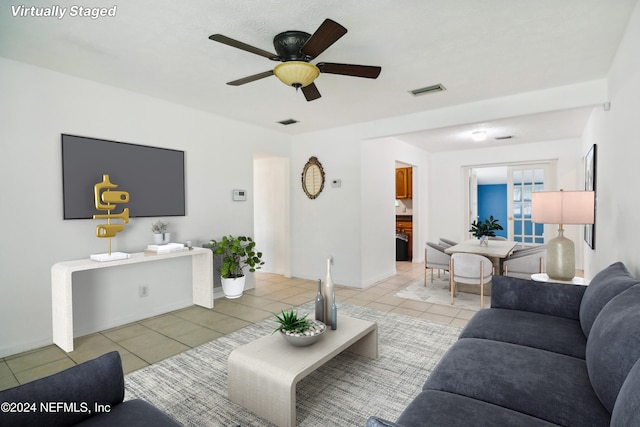 tiled living room with ceiling fan