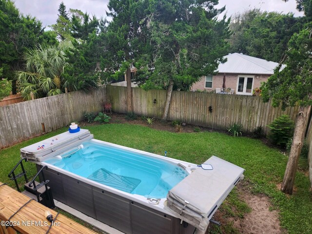 view of swimming pool with a hot tub and a lawn