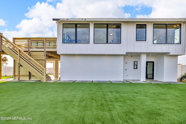 rear view of property featuring a wooden deck and a yard