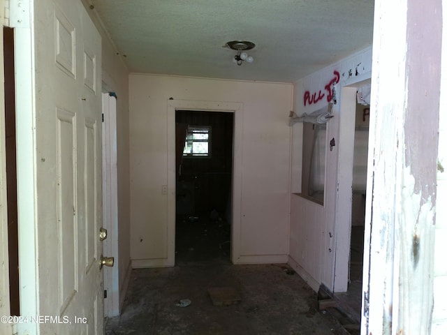 hall with a textured ceiling