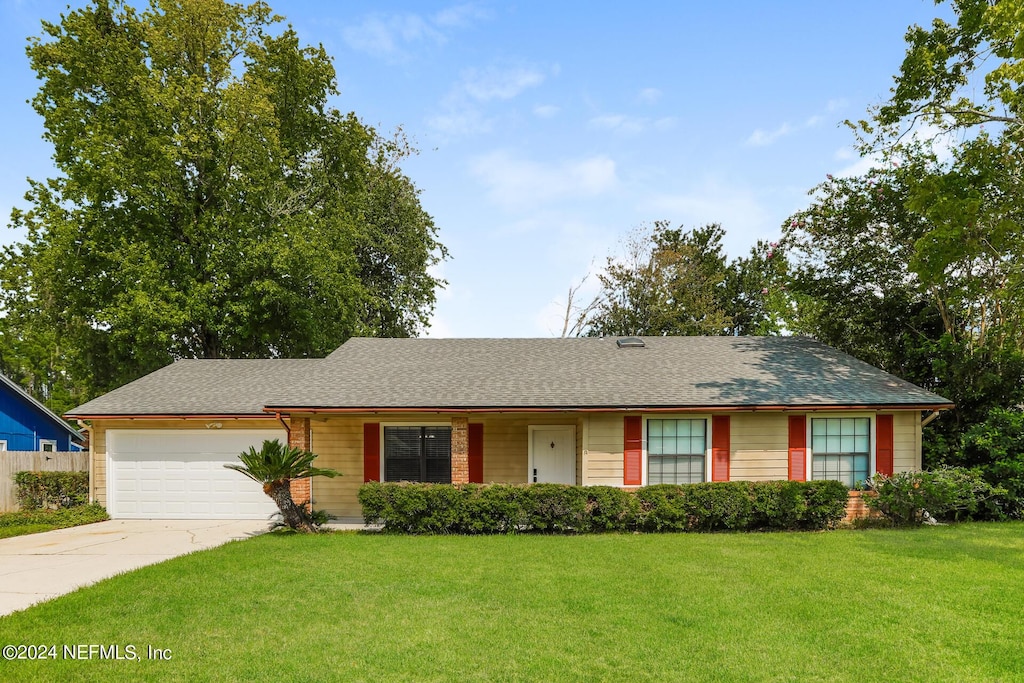 ranch-style home featuring a garage and a front yard