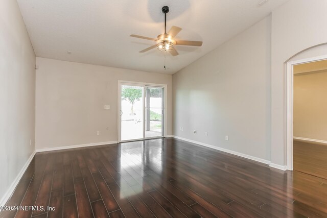 spare room with dark wood-type flooring, lofted ceiling, and ceiling fan