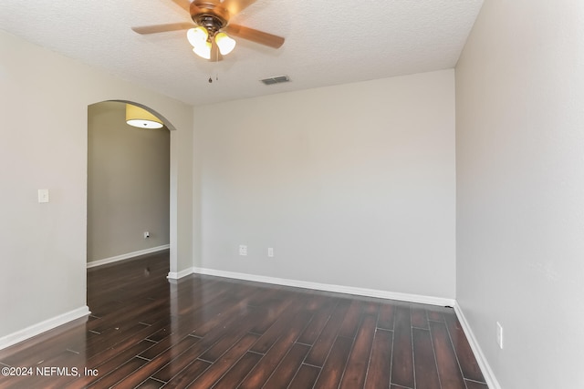 unfurnished room with a textured ceiling, dark wood-type flooring, and ceiling fan