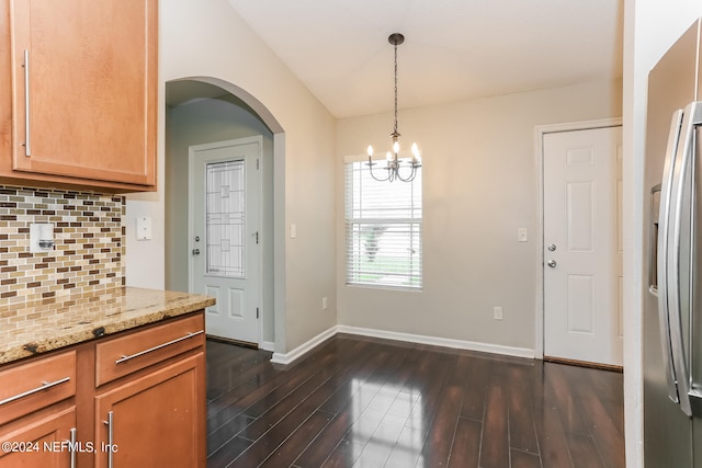 kitchen featuring a notable chandelier, decorative light fixtures, light stone counters, dark hardwood / wood-style floors, and stainless steel refrigerator with ice dispenser