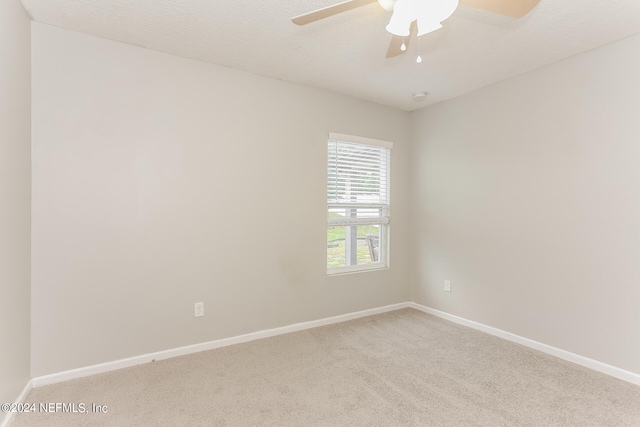 empty room featuring a textured ceiling, ceiling fan, and carpet floors