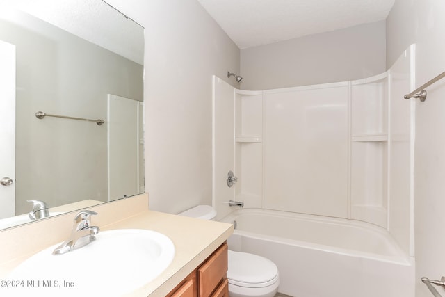 full bathroom with a textured ceiling, vanity, toilet, and washtub / shower combination