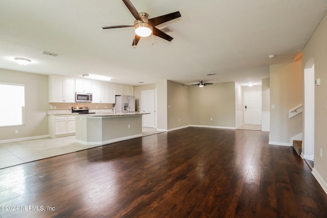 unfurnished living room featuring ceiling fan, sink, and light wood-type flooring