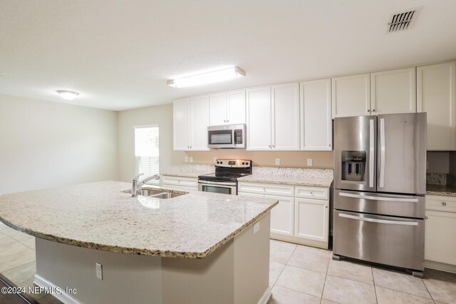 kitchen featuring white cabinets, light stone countertops, stainless steel appliances, and sink