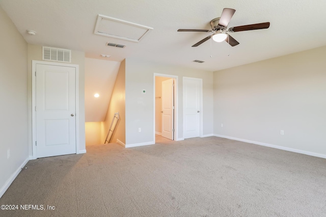 unfurnished bedroom with attic access, carpet flooring, and visible vents