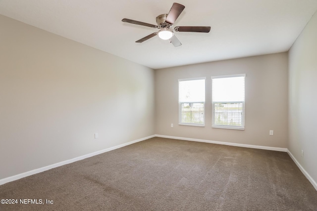 empty room with a ceiling fan, baseboards, and carpet floors