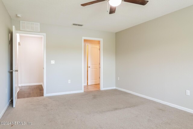 unfurnished bedroom with ceiling fan and light carpet