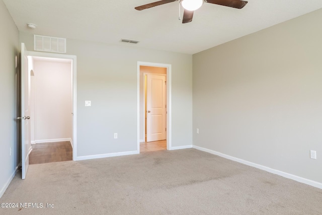 unfurnished bedroom with baseboards, visible vents, carpet floors, and ceiling fan