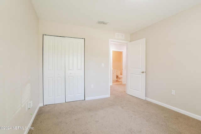 unfurnished bedroom featuring visible vents, carpet floors, baseboards, and a closet