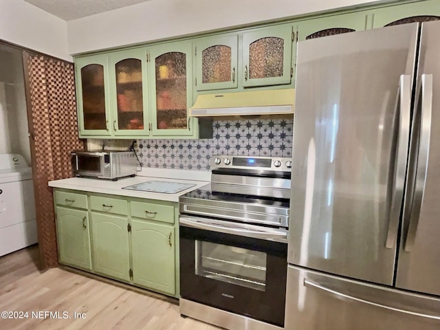 kitchen featuring appliances with stainless steel finishes, backsplash, and green cabinetry