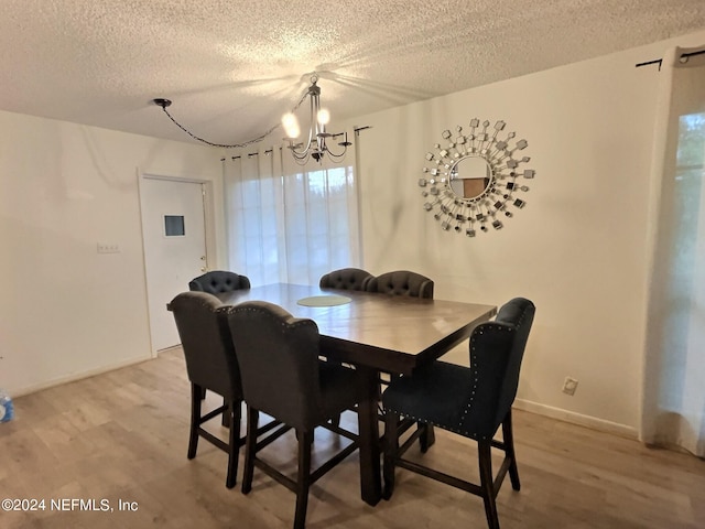 dining room featuring a textured ceiling and light hardwood / wood-style floors