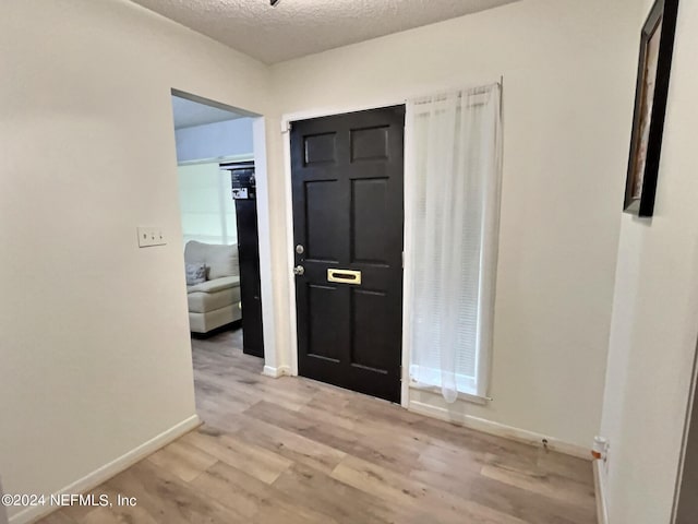 entryway featuring a textured ceiling and light hardwood / wood-style floors