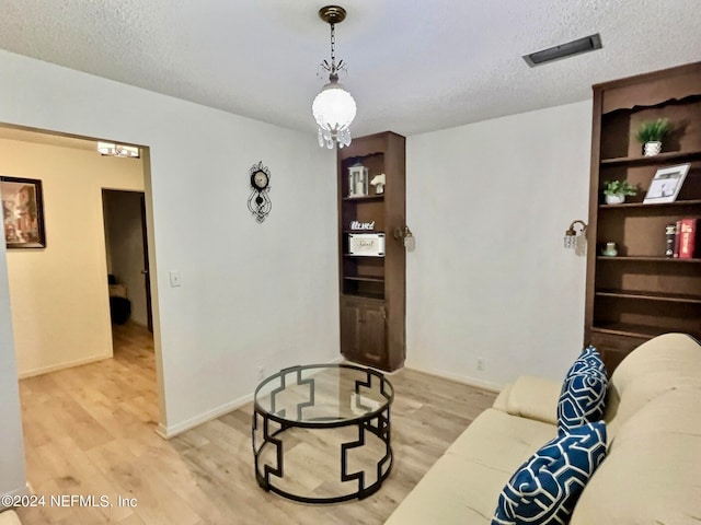 living room with light wood-type flooring and a textured ceiling