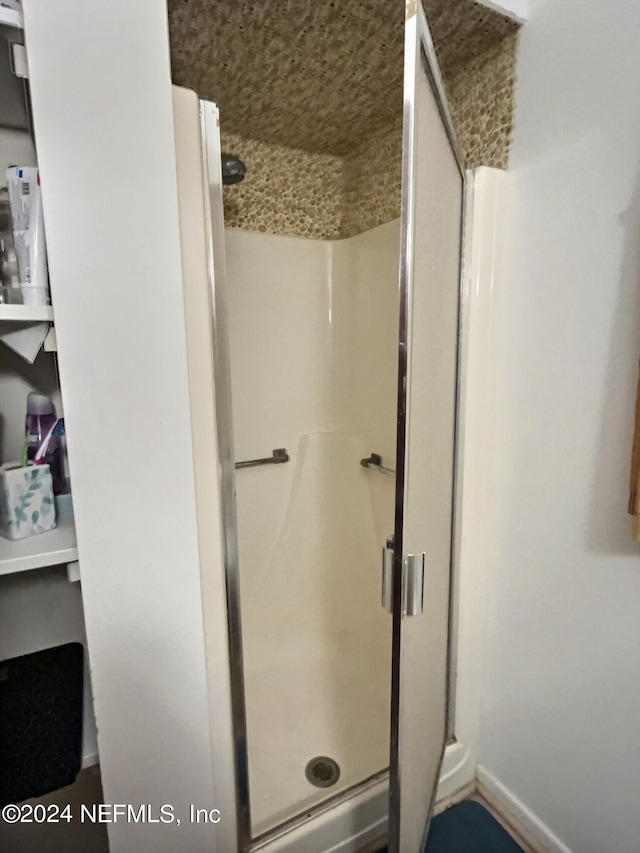 bathroom featuring a shower with door