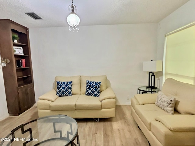 living room with a textured ceiling and light hardwood / wood-style floors