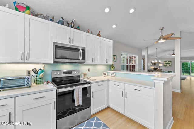 kitchen featuring white cabinets, appliances with stainless steel finishes, kitchen peninsula, and ceiling fan