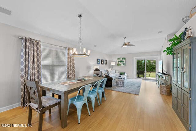 dining space with light hardwood / wood-style flooring and ceiling fan with notable chandelier