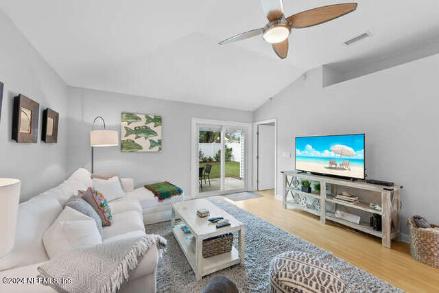 living room with vaulted ceiling, wood-type flooring, and ceiling fan