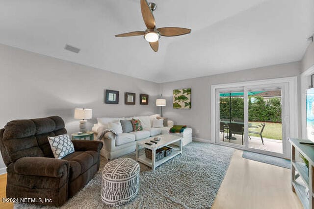 living room featuring lofted ceiling, hardwood / wood-style floors, and ceiling fan