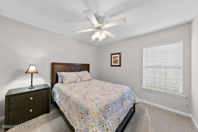 bedroom featuring ceiling fan and carpet