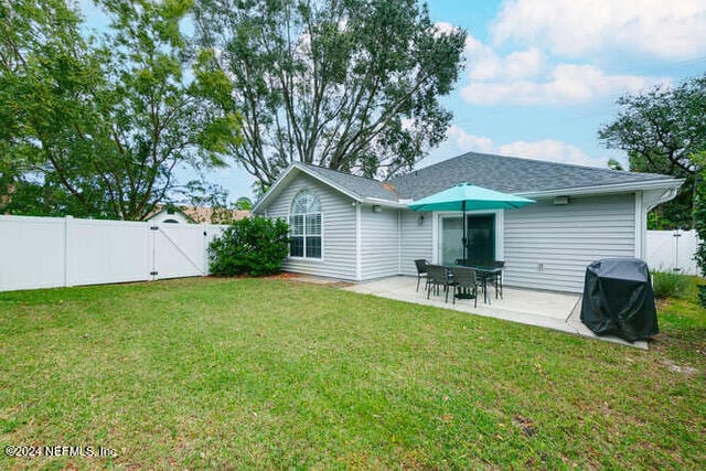 back of house featuring a yard and a patio