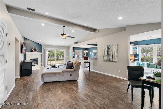 living room featuring a textured ceiling, ceiling fan with notable chandelier, vaulted ceiling with beams, and dark hardwood / wood-style floors