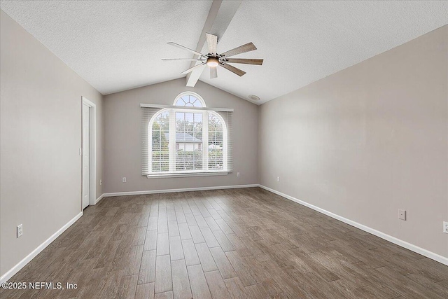 spare room featuring a textured ceiling, ceiling fan, dark hardwood / wood-style flooring, and vaulted ceiling with beams