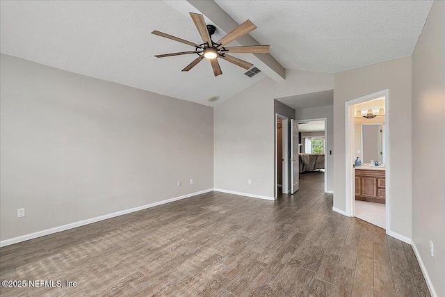 unfurnished living room featuring a textured ceiling, ceiling fan, dark hardwood / wood-style flooring, and vaulted ceiling with beams