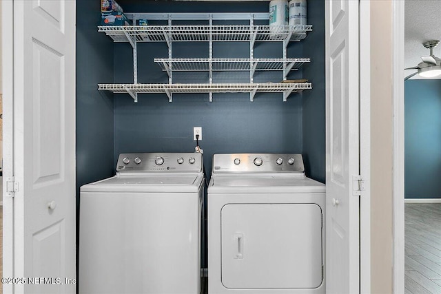 washroom featuring washer and dryer, ceiling fan, and wood-type flooring