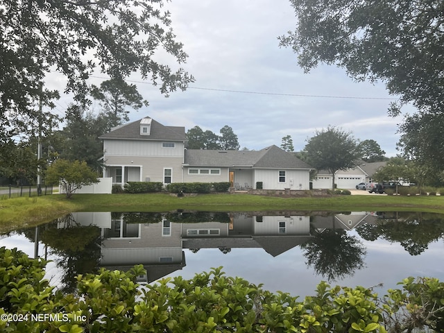 back of house with a water view and fence