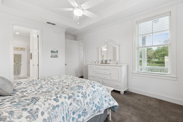 bedroom featuring visible vents, a tray ceiling, crown molding, dark colored carpet, and baseboards