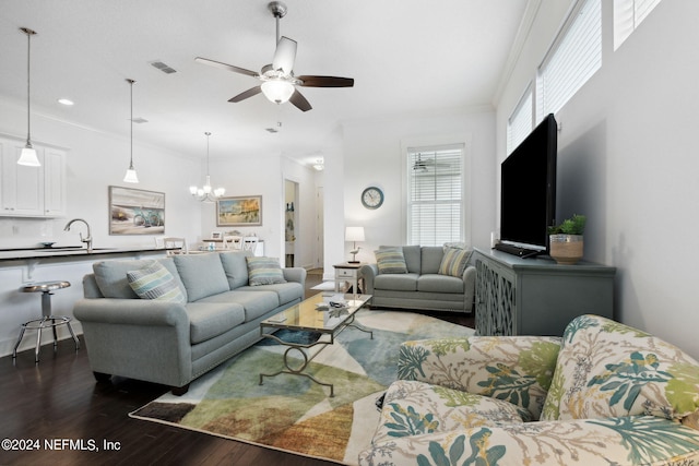 living area with visible vents, recessed lighting, dark wood-type flooring, crown molding, and ceiling fan with notable chandelier