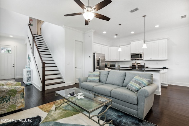 living area with stairs, baseboards, dark wood-style flooring, and ornamental molding