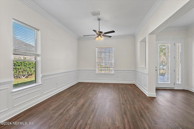 empty room with a textured ceiling, ceiling fan, dark wood-type flooring, and a wealth of natural light