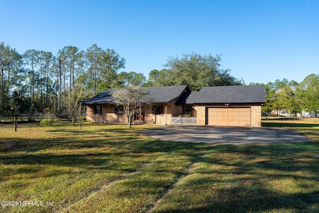 ranch-style house featuring a front yard and a garage