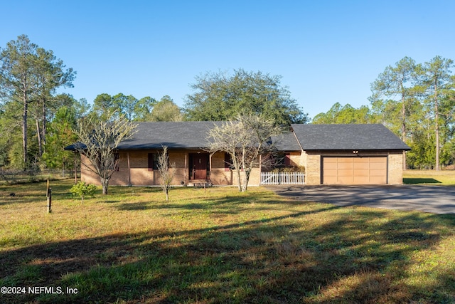 ranch-style home featuring a front lawn and a garage