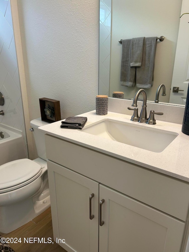 full bathroom featuring wood-type flooring, vanity, toilet, and shower / tub combination