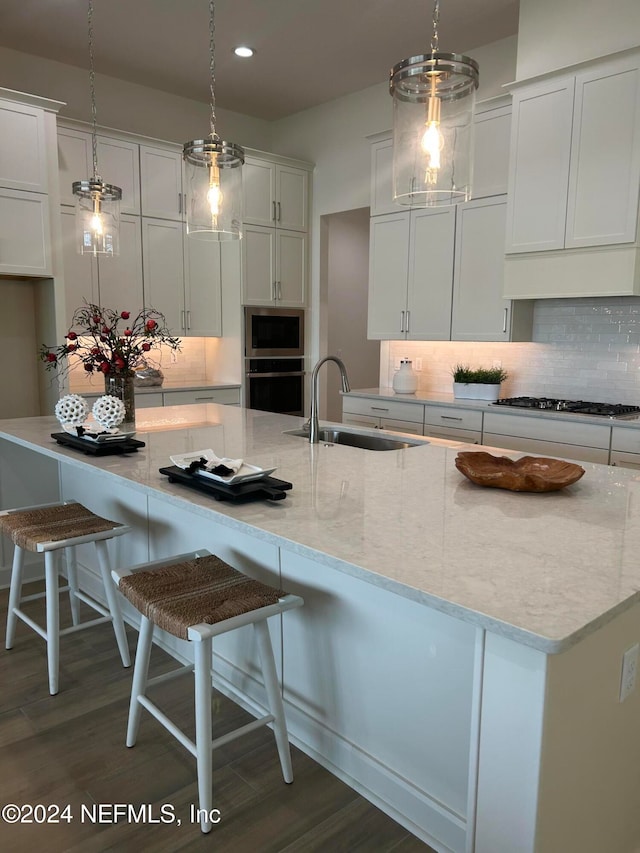 kitchen with decorative light fixtures, dark hardwood / wood-style flooring, stainless steel appliances, and sink