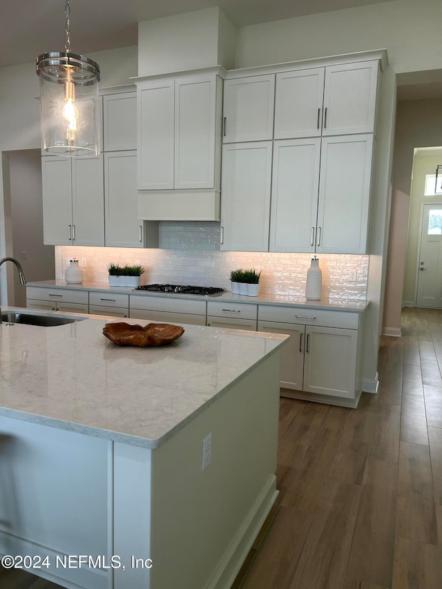 kitchen with white cabinetry, sink, wood-type flooring, pendant lighting, and stainless steel gas stovetop