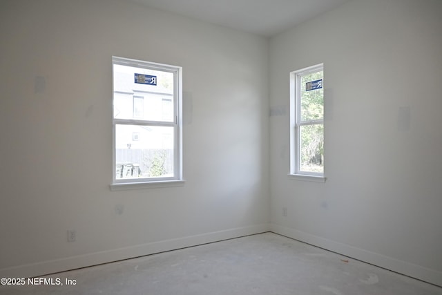 empty room with concrete floors and baseboards