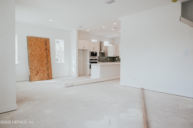 unfurnished living room with recessed lighting and visible vents