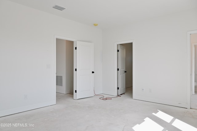 unfurnished bedroom with visible vents, concrete floors, and baseboards